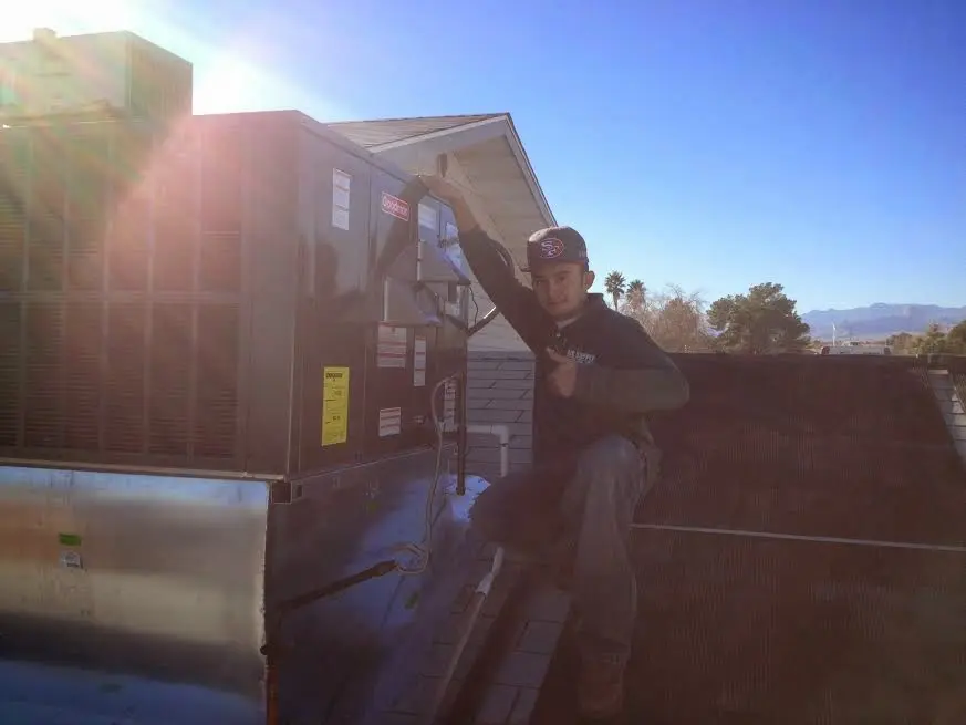 HVAC technician performing AC Tune-Up on a rooftop unit in Columbia